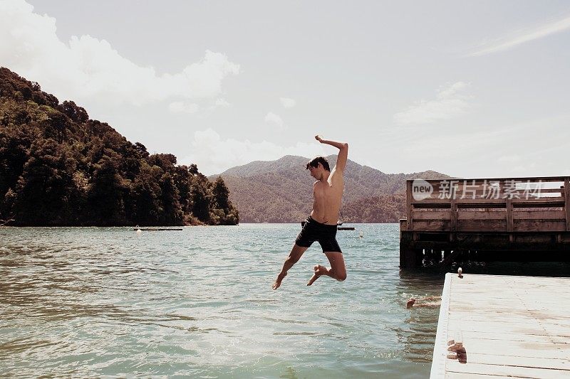 Boy Jumping from Jetty into Sea